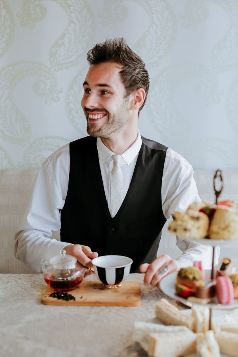 gentleman sitting with a cup of tea and a high tea